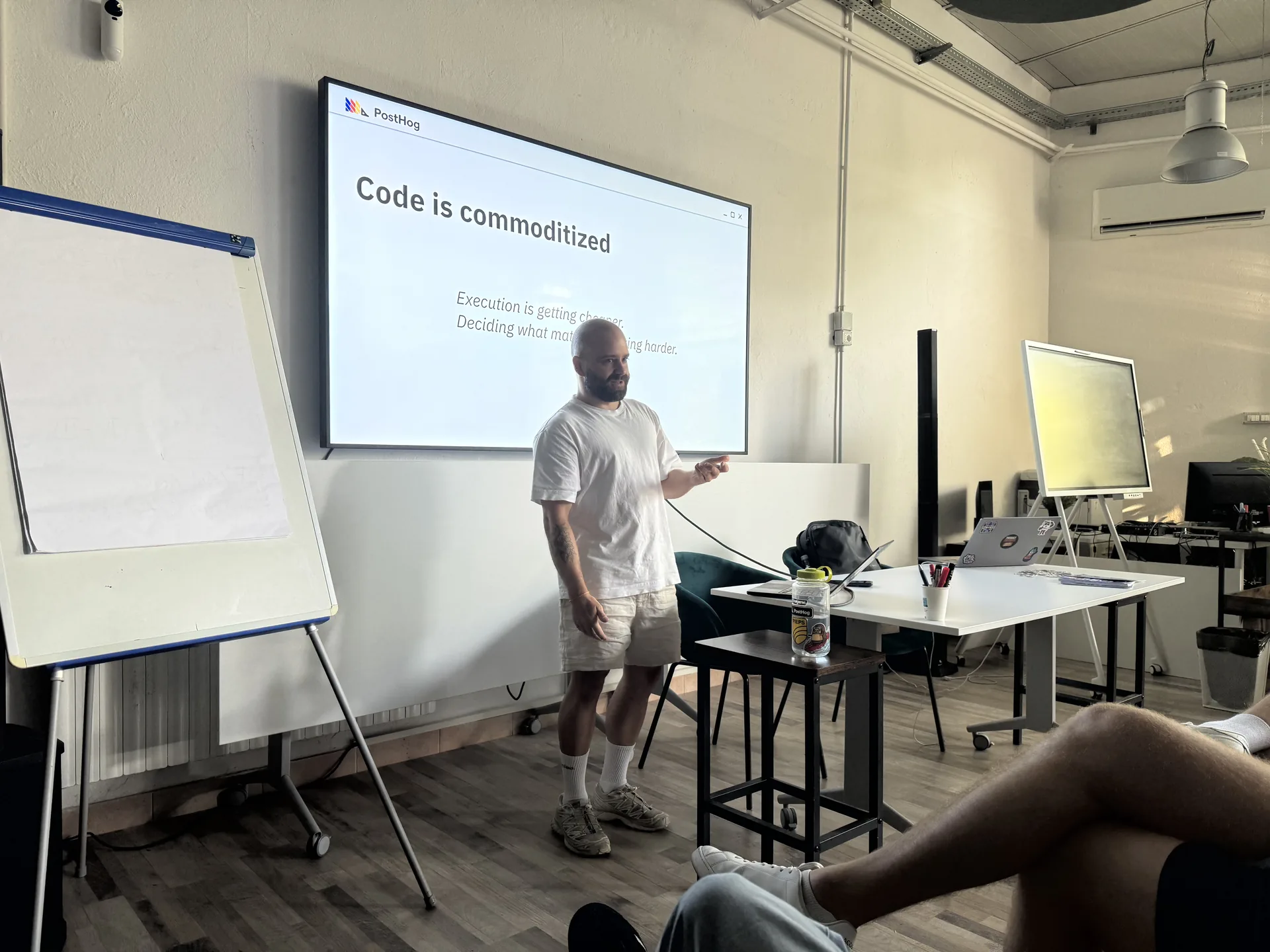 Meikel Ratz presenting a slide about code becoming commoditised