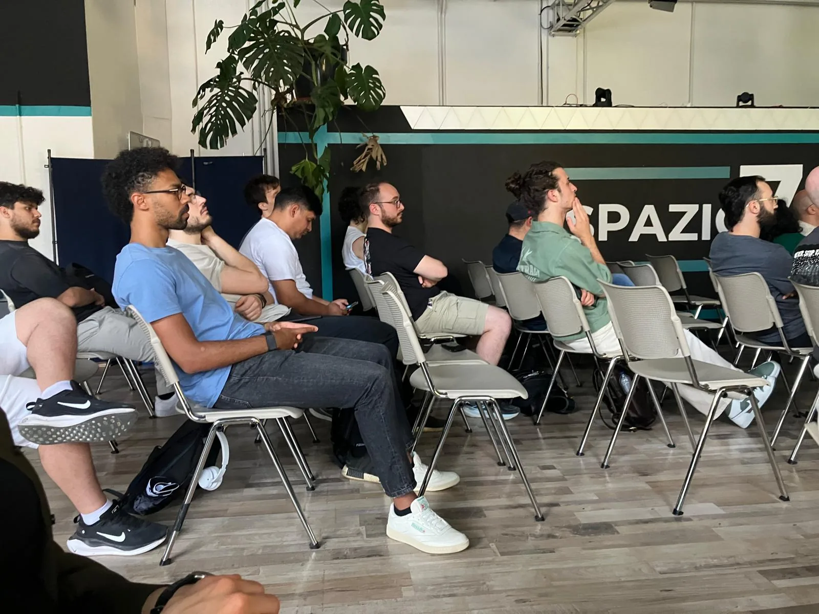 Attendees listening to a talk beneath the Spazio 78 sign